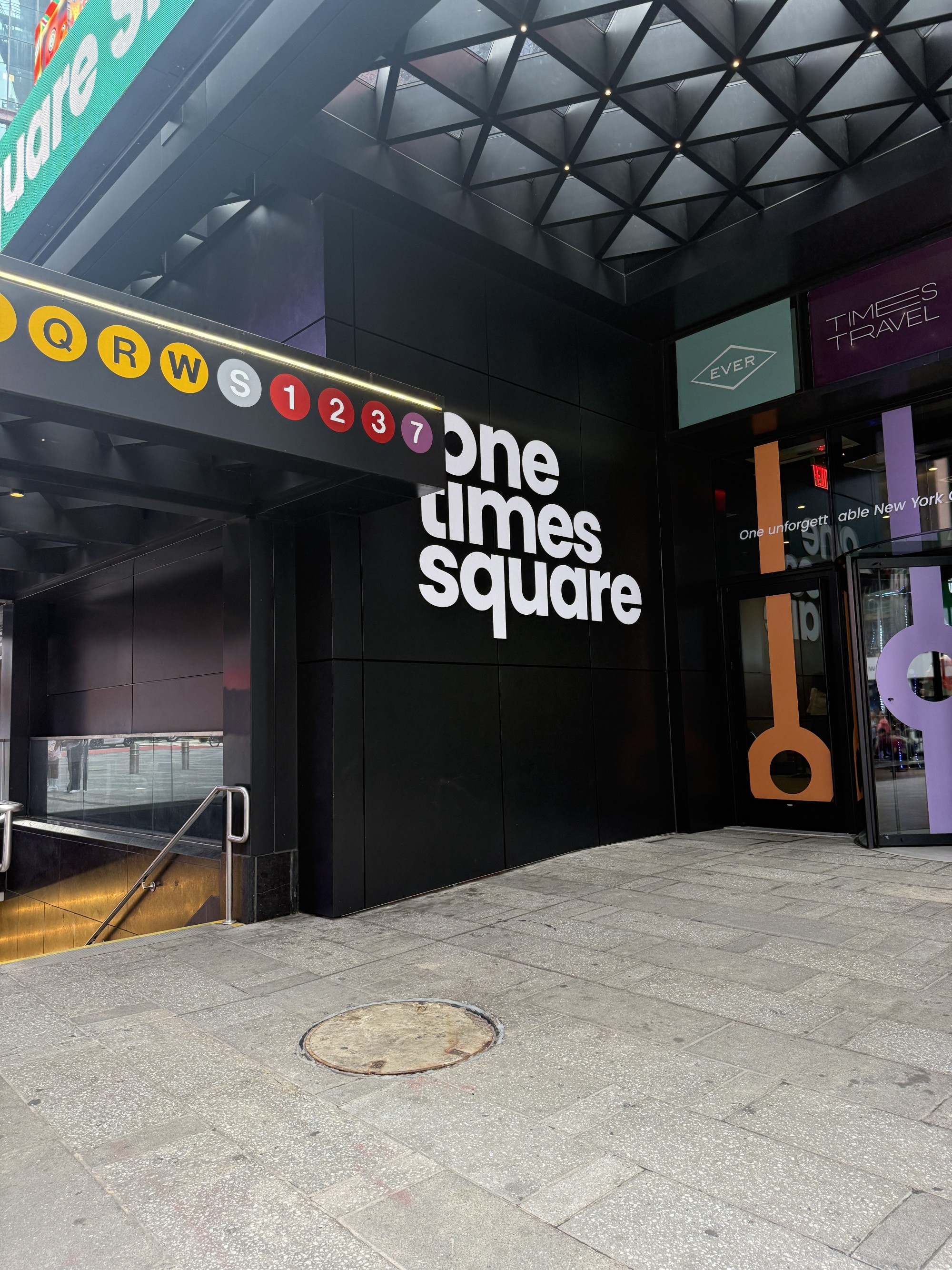 One Times Square 문구가 적힌 표지판과 계단이 있는 건물 입구 모습