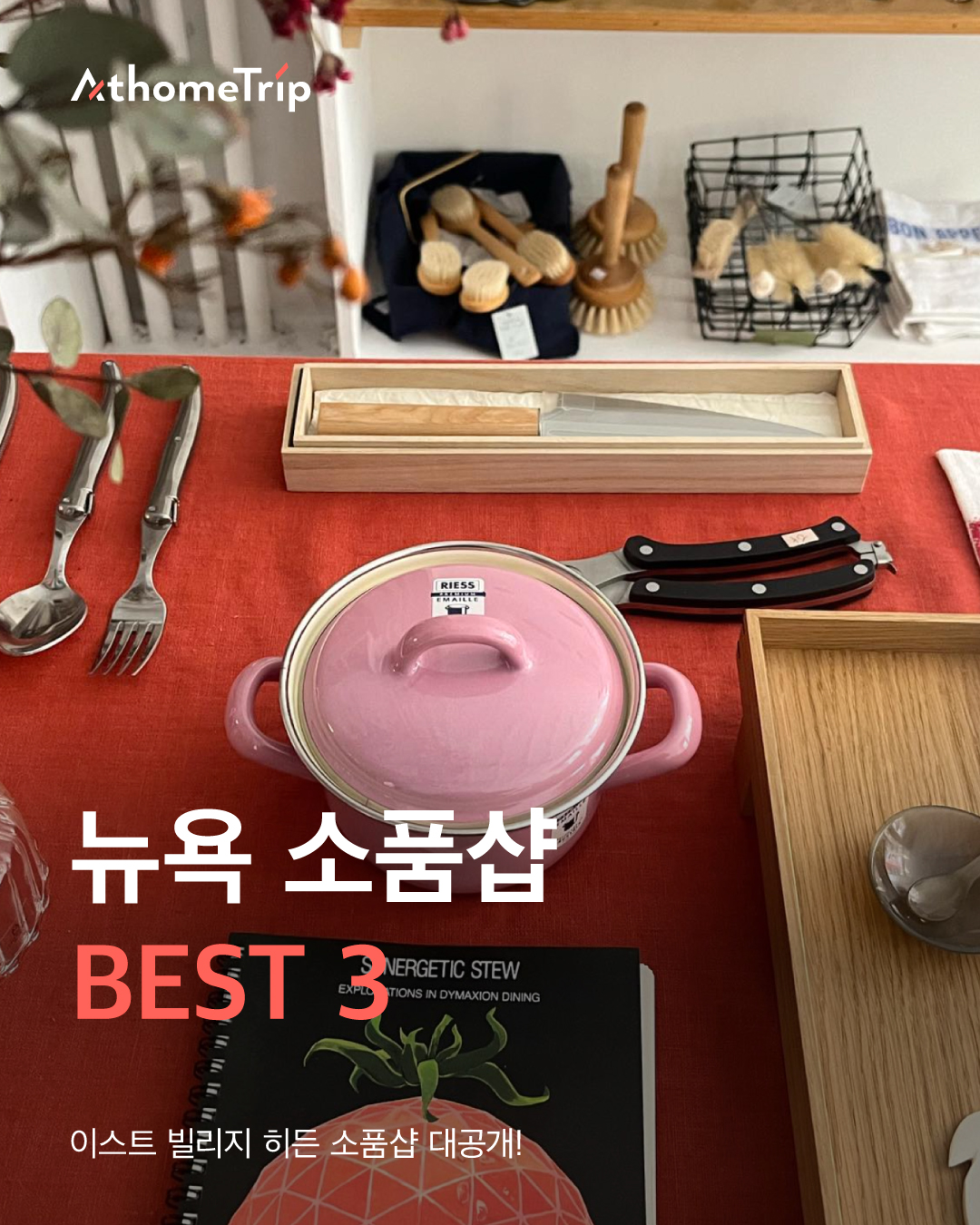 주방 테이블 위에 놓인 분홍색 주방용기와 식기류, 책과 나무 상자
