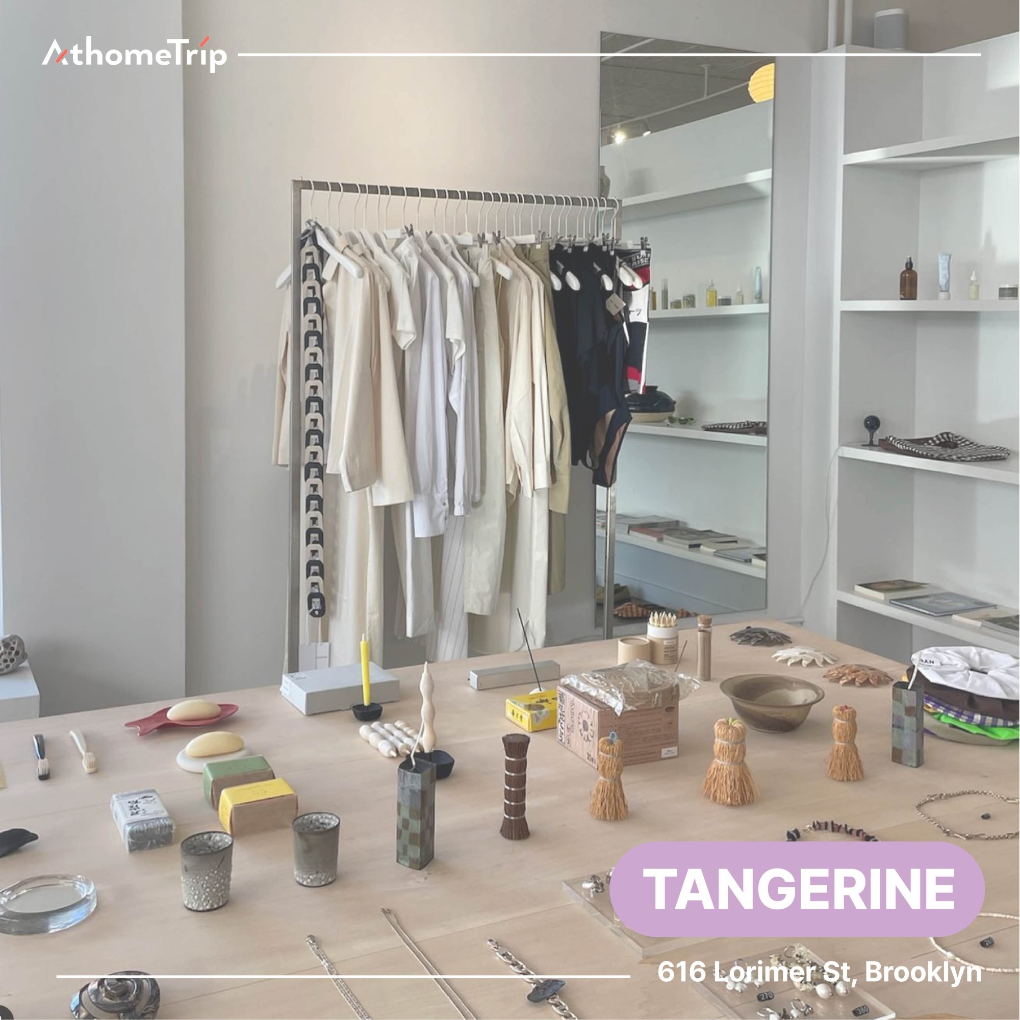 TANGERINE 문구가 보이는 실내 전시 공간에 옷걸이와 테이블 위의 접시, 병 등 소품이 배치된 모습
