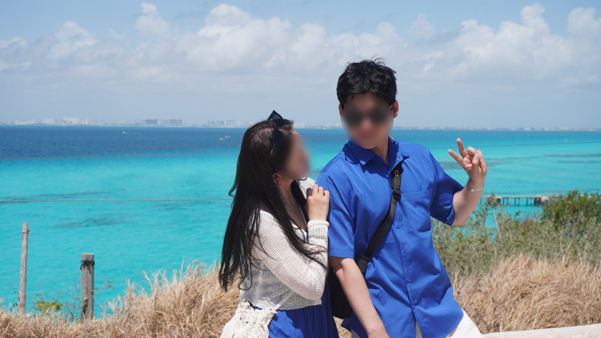 해변에 두 사람과 바다 그리고 하늘이 보이는 풍경