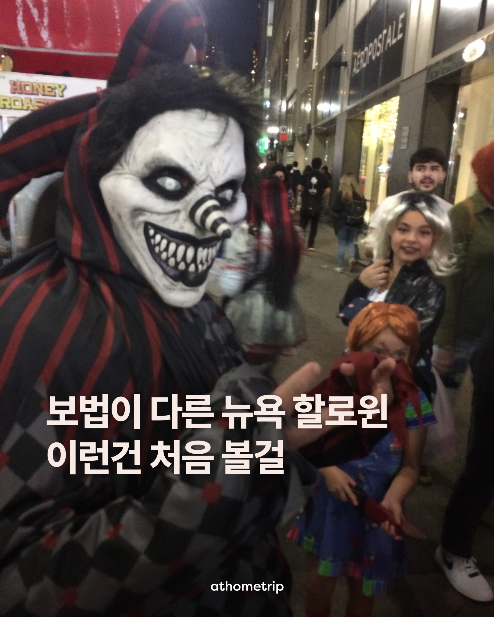 밤거리에서 다양한 마스크와 의상을 착용한 사람들이 건물 앞에 모여 있는 모습