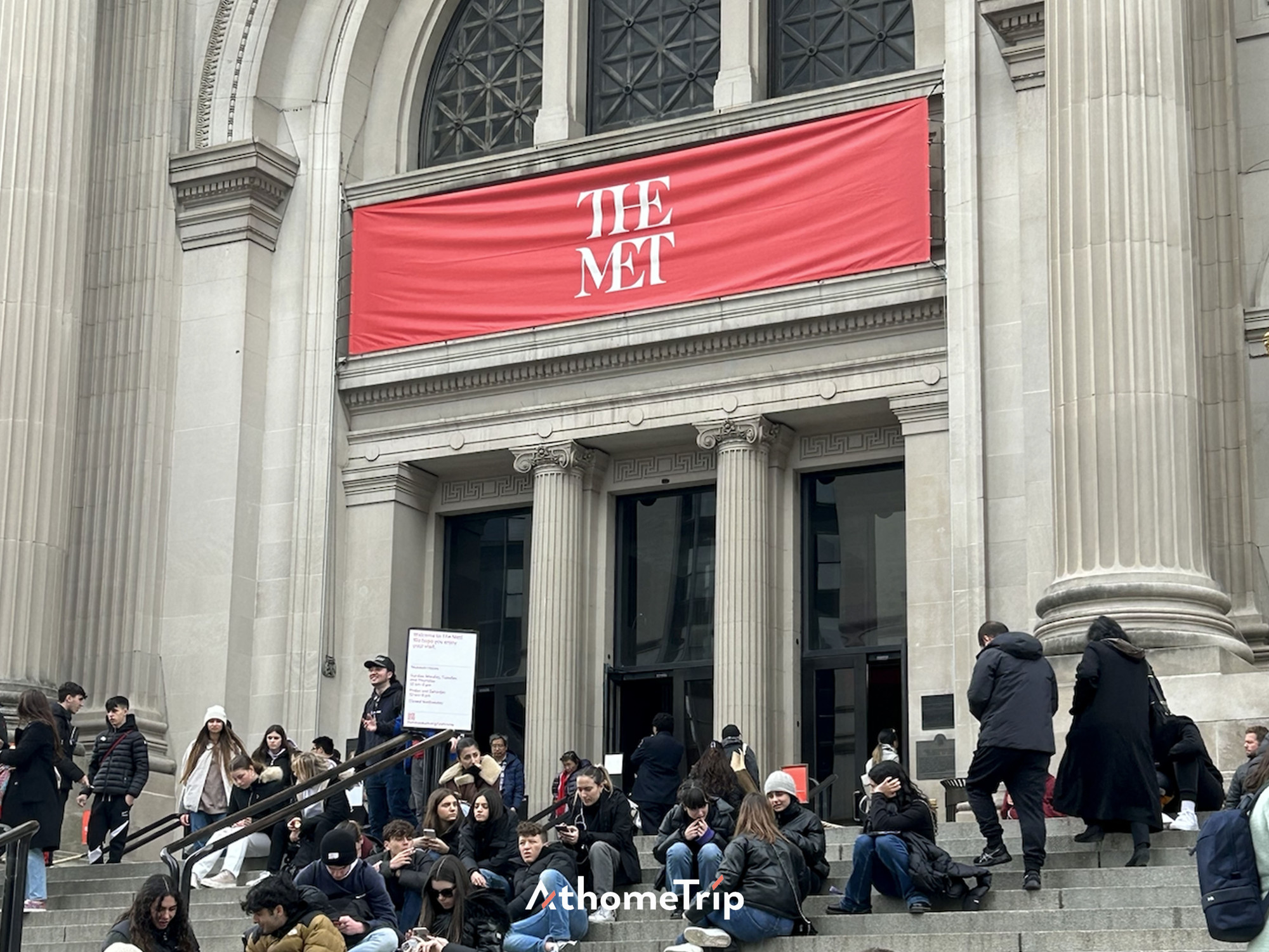 THE MET 문구가 보이는 대규모 건물 앞 계단에 사람들이 모여 있음