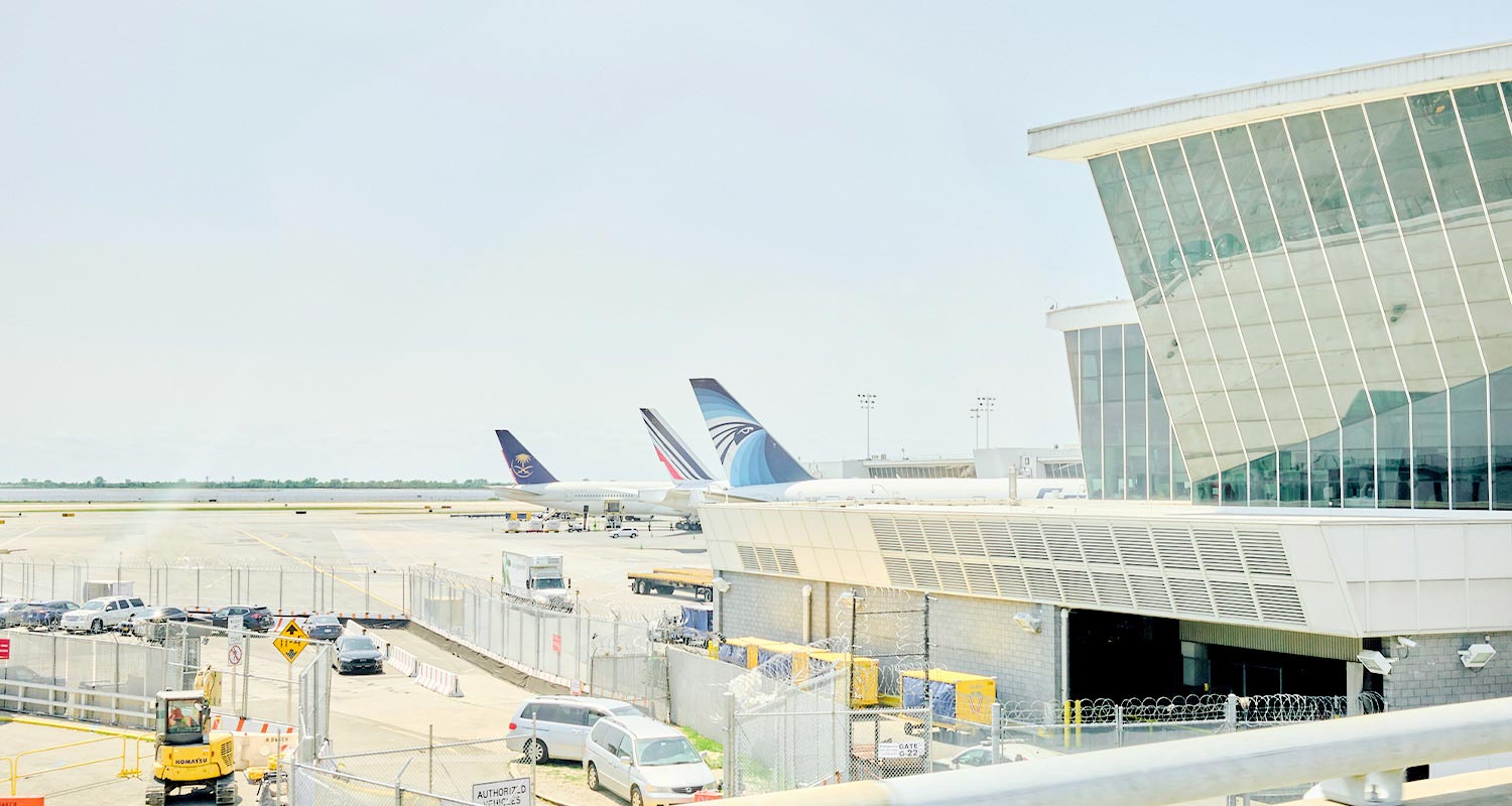 공항 활주로와 건물 그리고 비행기와 자동차가 보이는 실외 전경